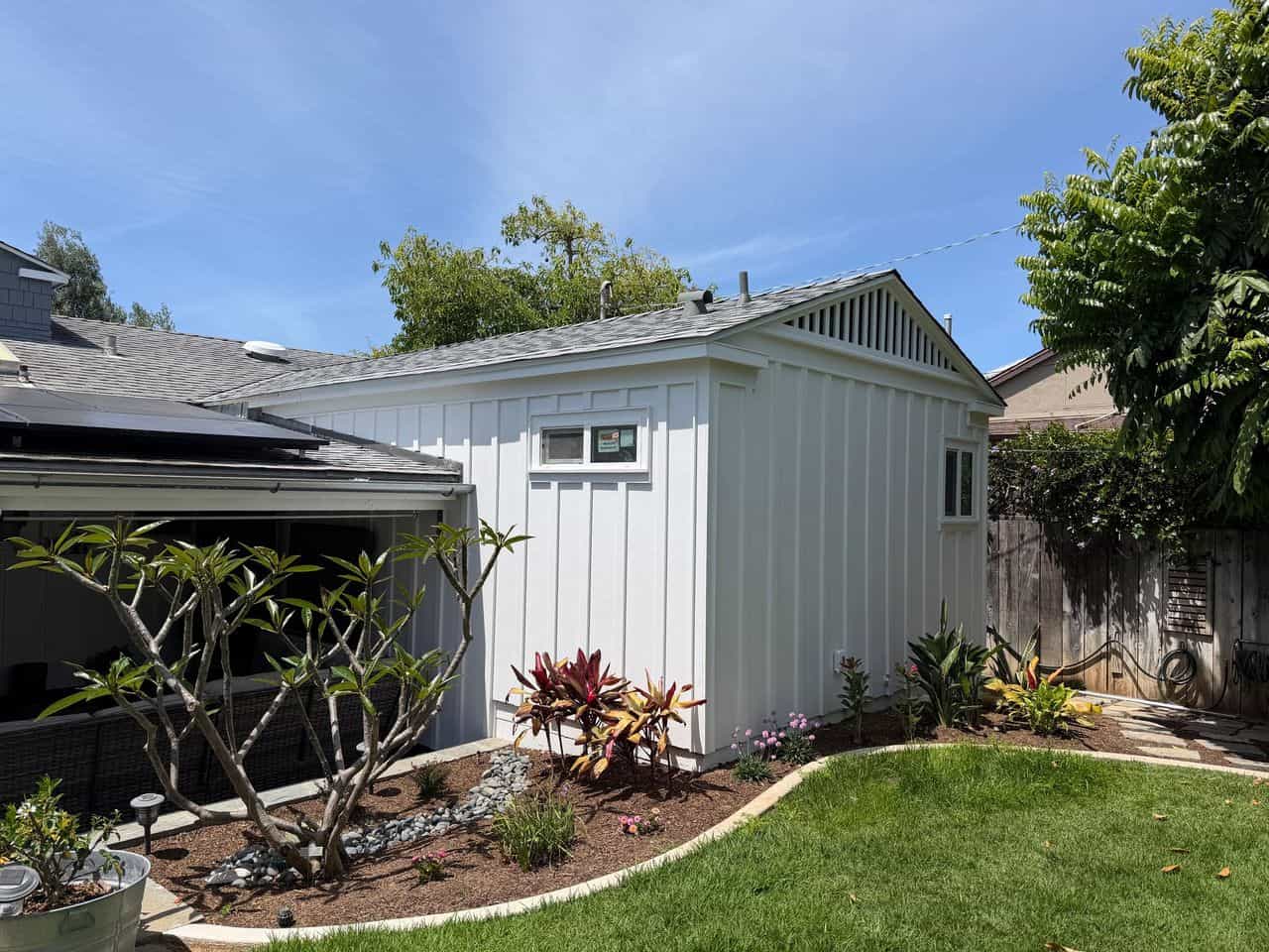 renovated white board and batten house exterior with garden