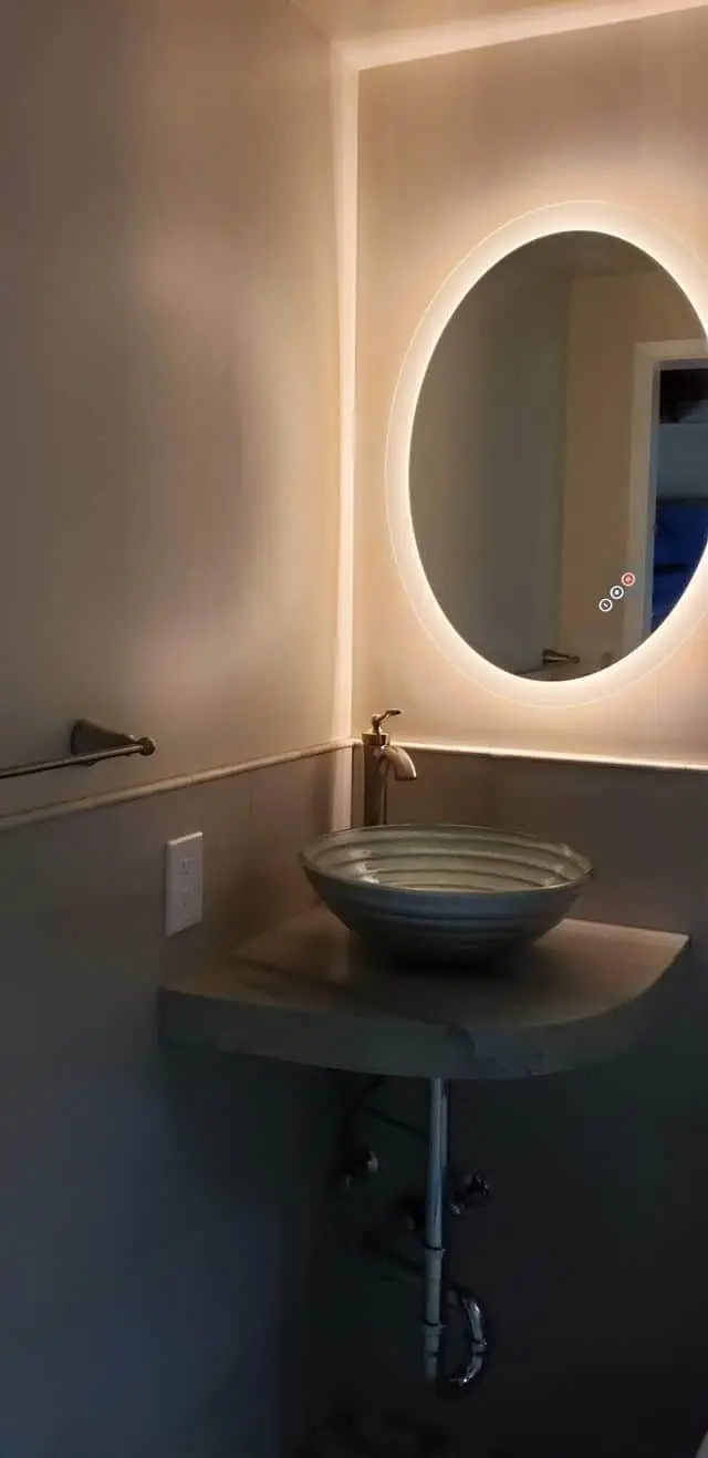 overhead sink and round backlit mirror
