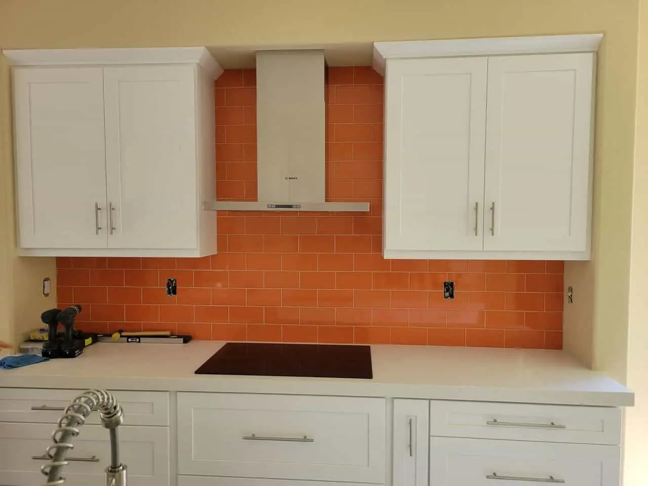 white kitchen with an orange backsplash