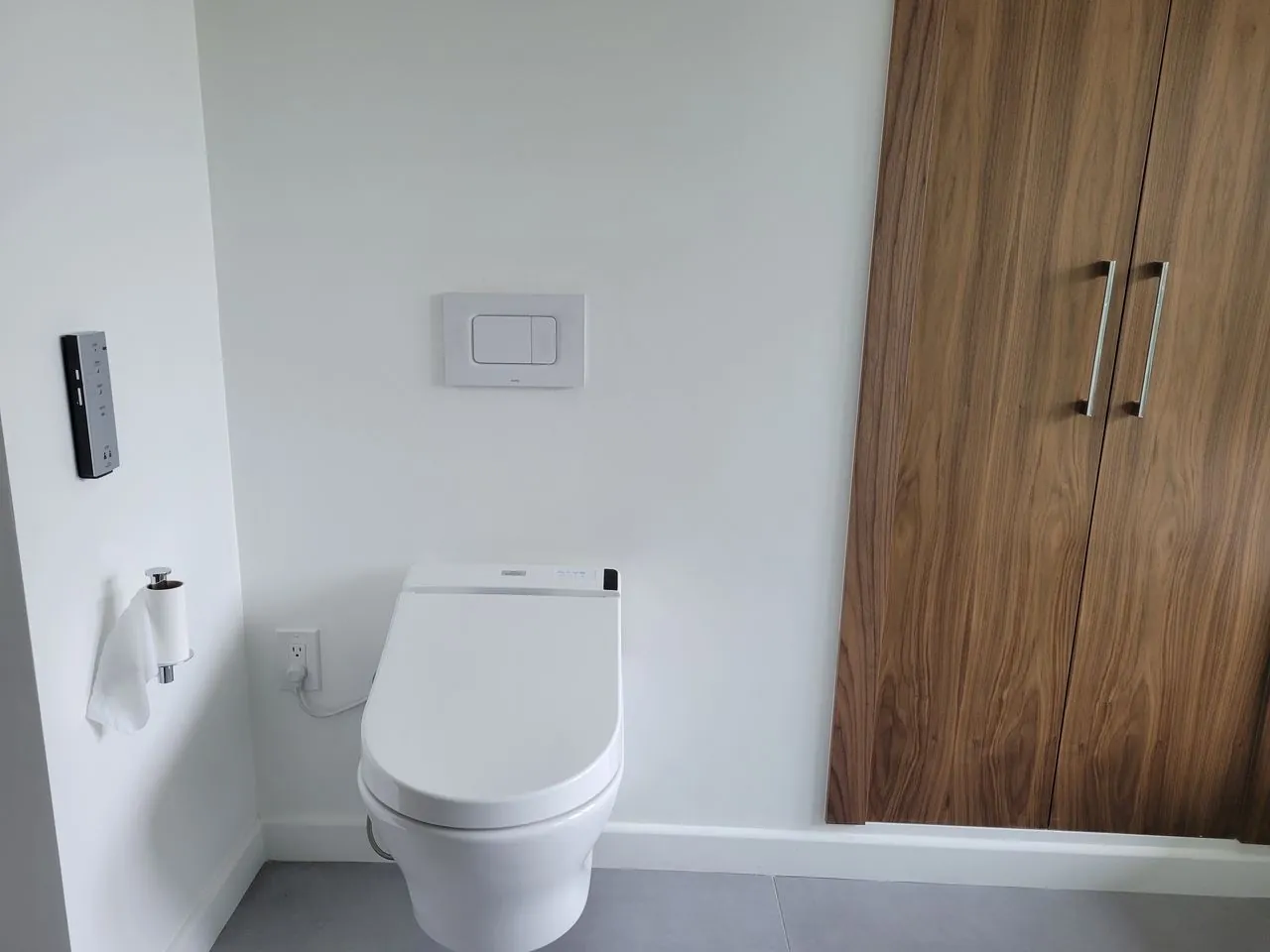 toilet next to a wooden cabinet