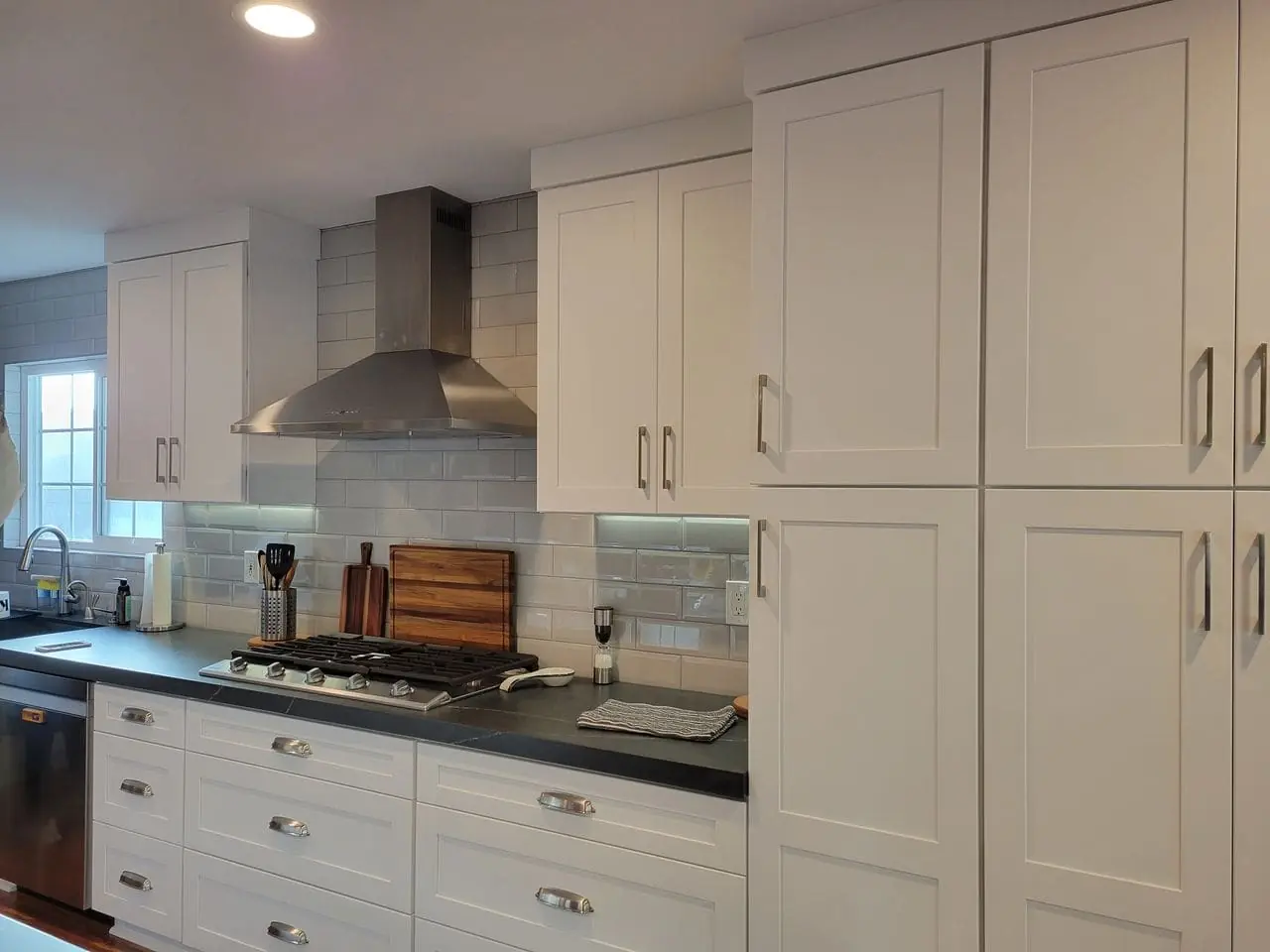 white kitchen facades with a dark marble countertop