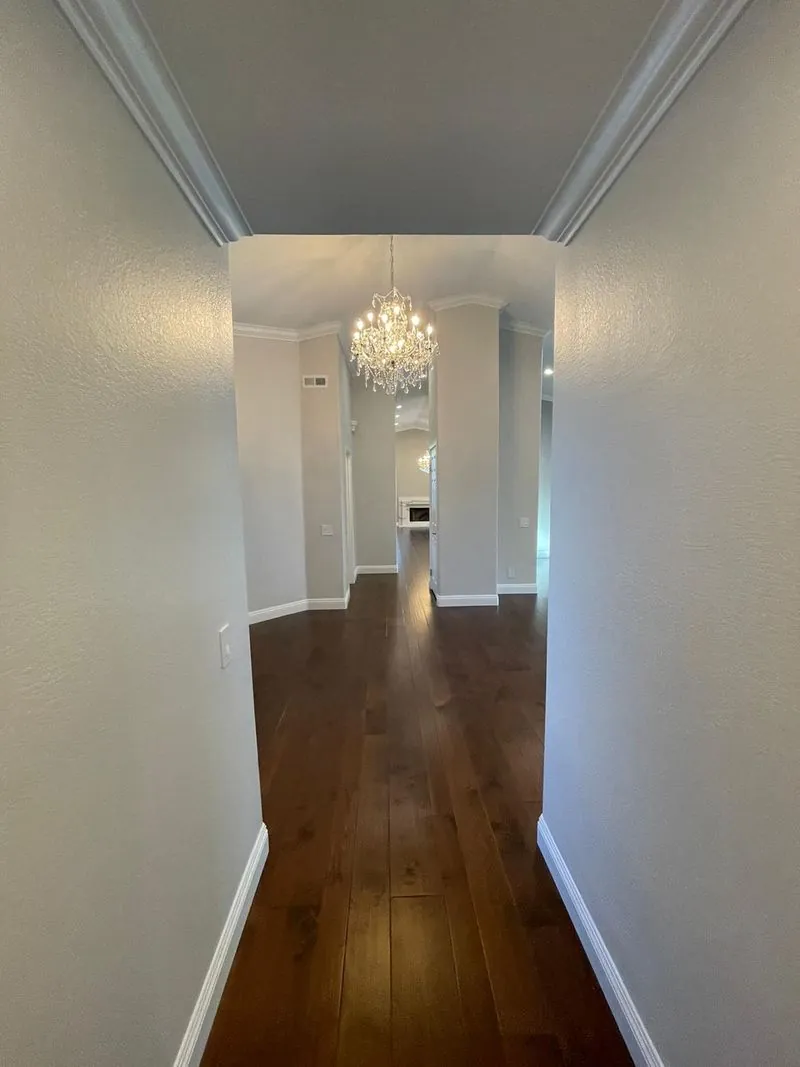 a spacious, bright corridor with a statement chandelier