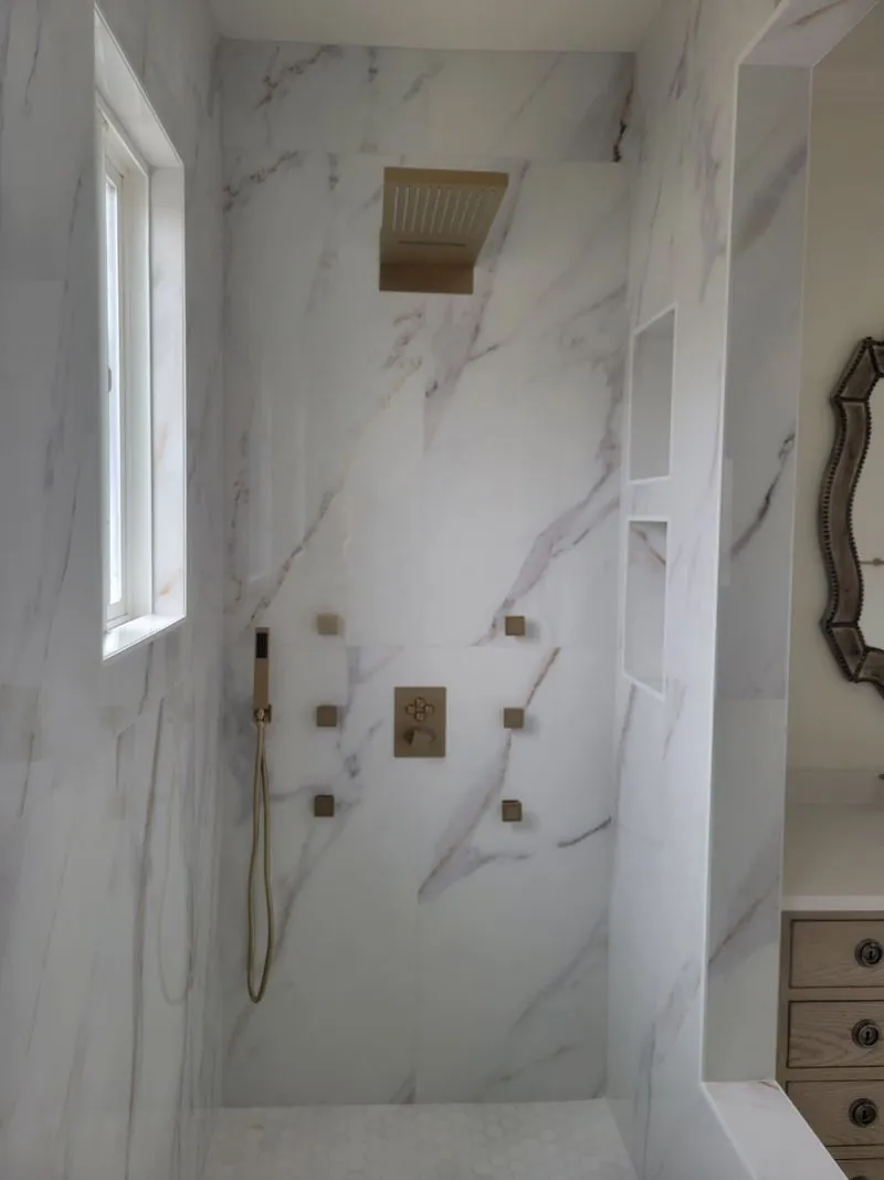 marble shower with gold fixtures