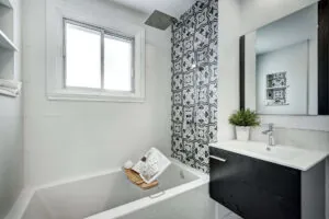 white bathroom with accent black tile in the shower
