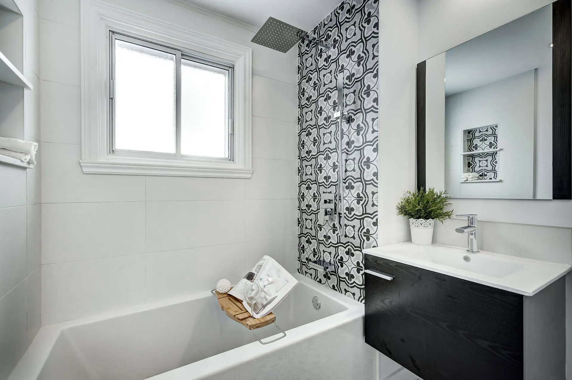white bathroom with accent black tile in the shower