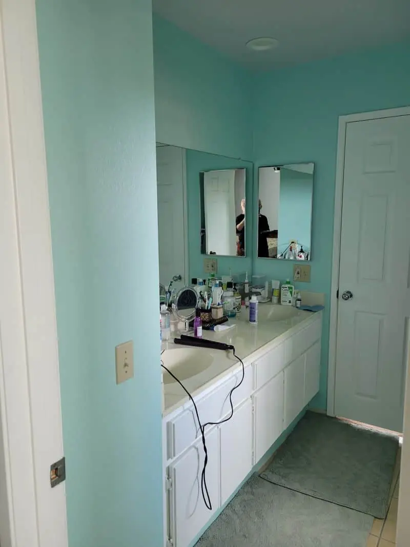 green bathroom with a white vanity